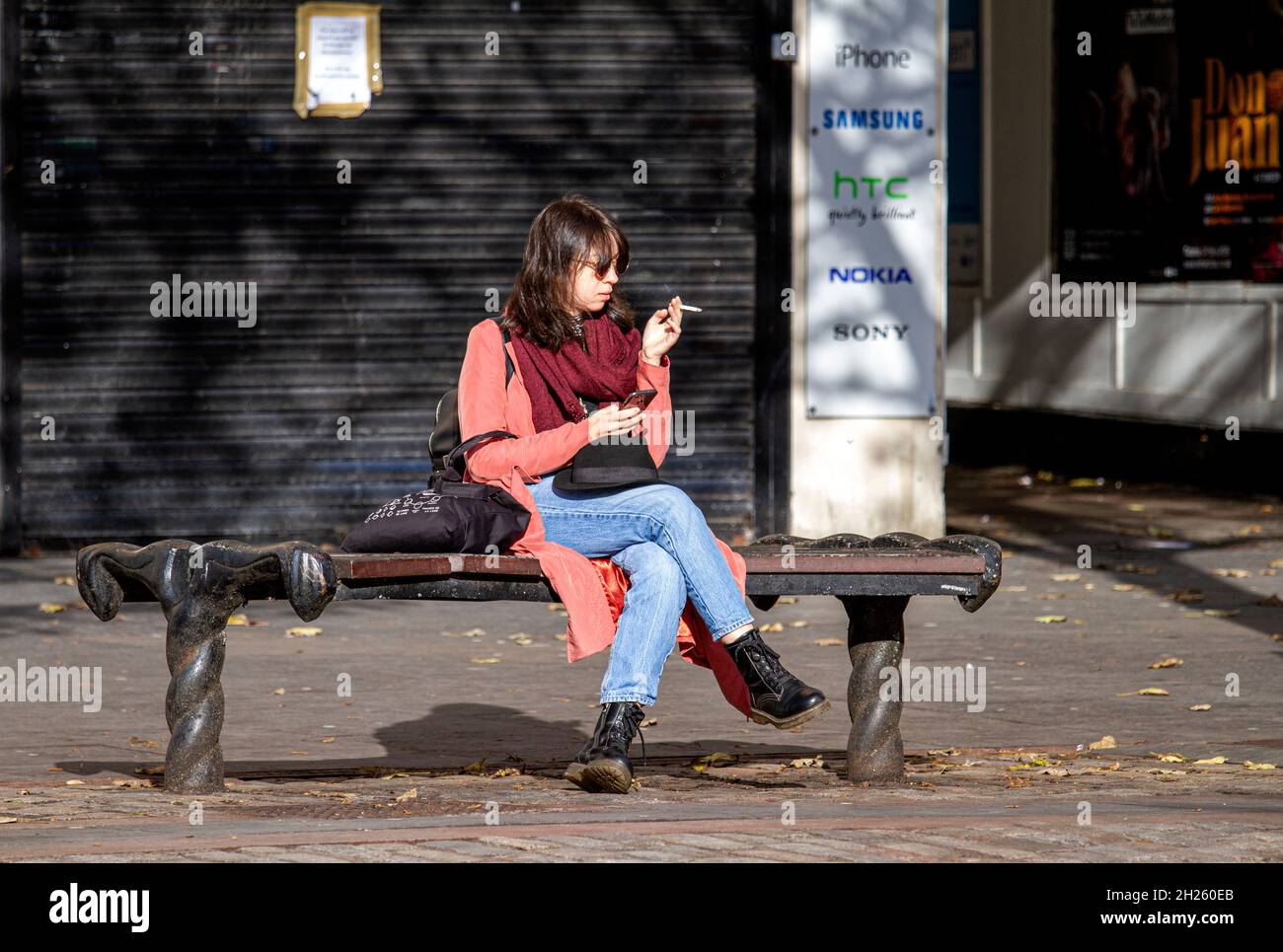 Dundee, Tayside, Scotland, UK. 20th Oct, 2021. UK Weather: A warm sunny Autumn day with a strong breeze across North East Scotland, temperatures reaching 14°C. An attractive young woman is spending the day out enjoying the October sunshine texting messages on her mobile phone whilst shopping in Dundee city centre. Credit: Dundee Photographics/Alamy Live News Stock Photo
