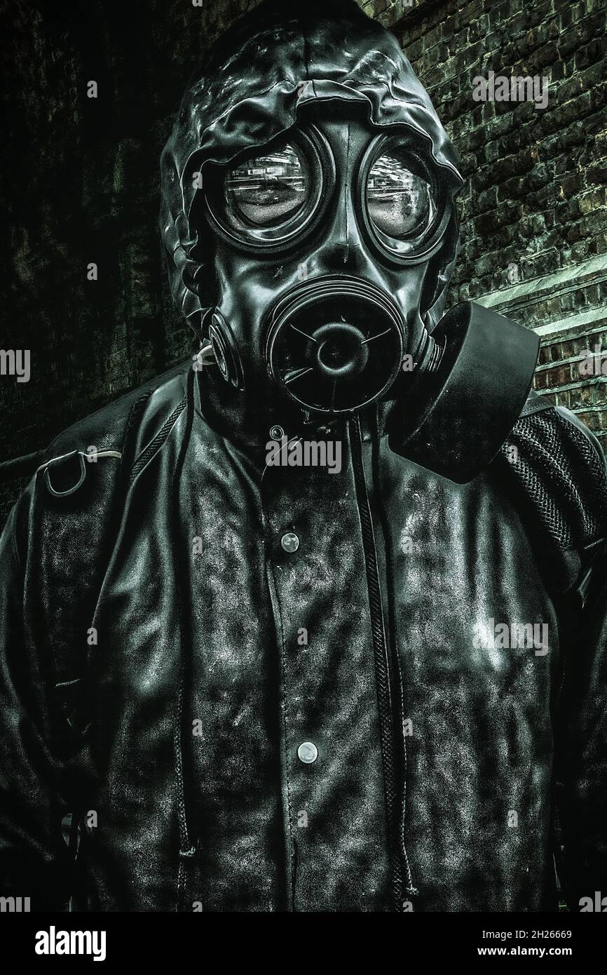 Man in Gas Mask  standing in a tunnel in Distorted cross processed tones Stock Photo