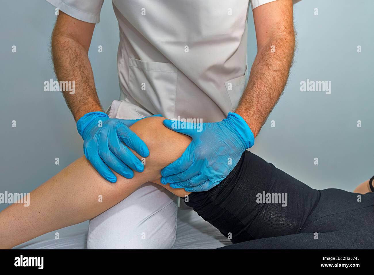 Physician working on examining a girl's injured foot Stock Photo