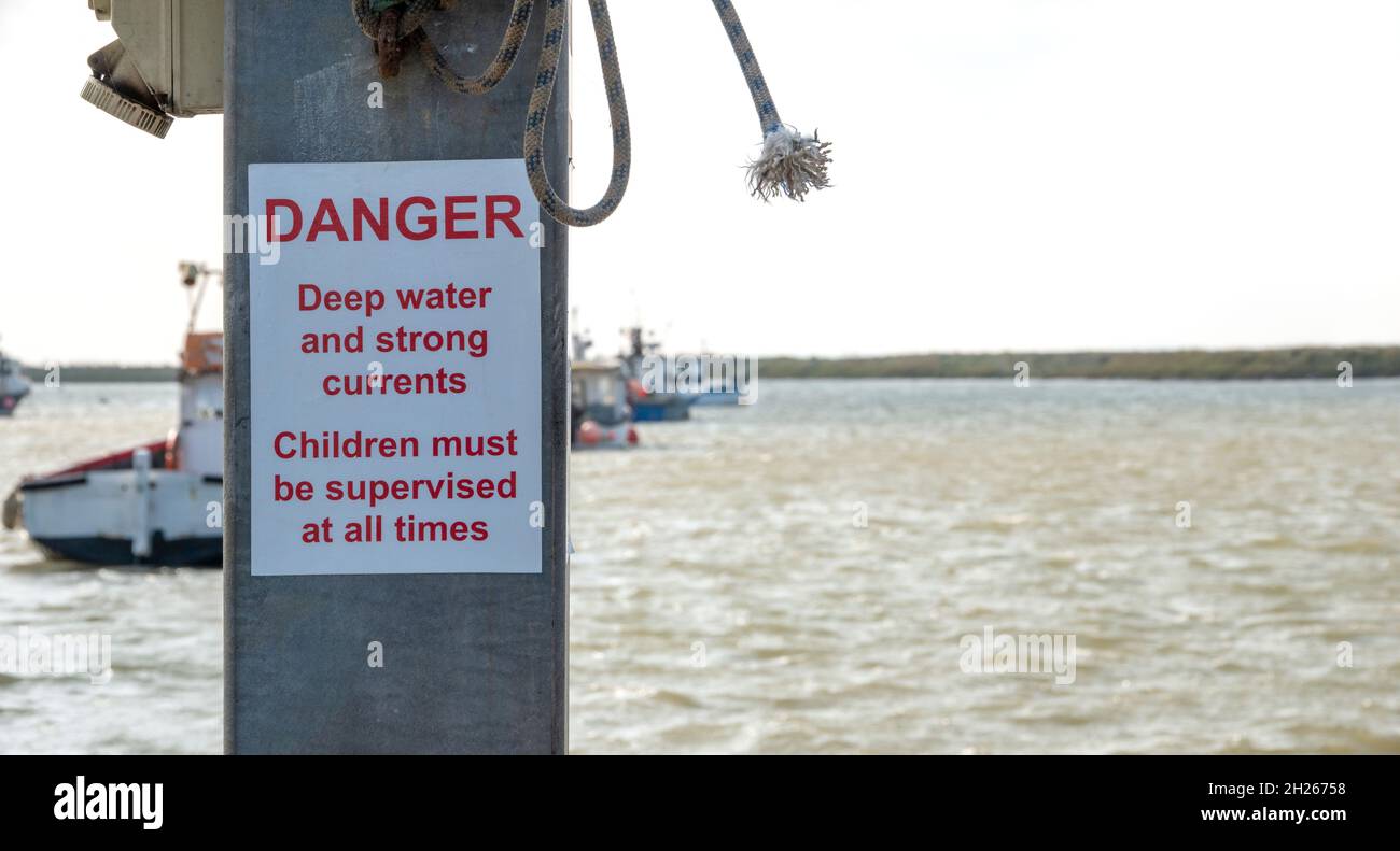 Danger warning sign of strong currents on the quay at Orford Ness Suffolk Stock Photo