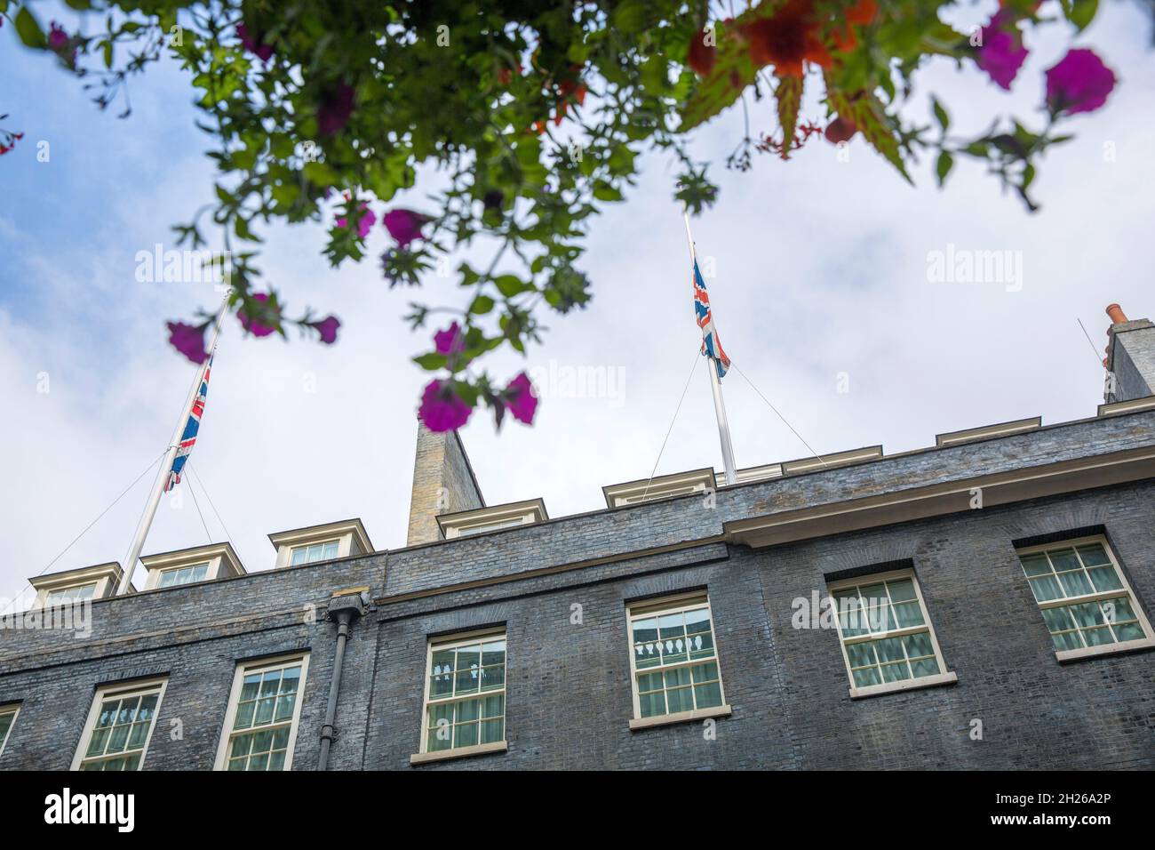 Union Flags fly at halfmast on the top of the building that houses 10