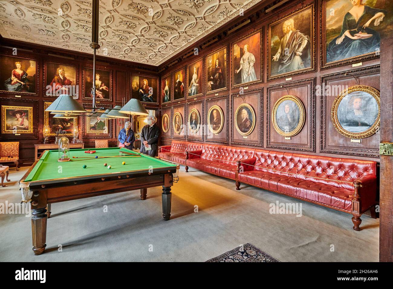 Visitors in the billiard room at Burghley House, an elizabethan mansion built by William Cecil, Lord Burghley, at Stamford in 16 century England. Stock Photo