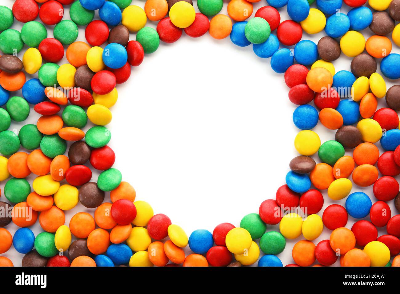 Frame made of colorful candies on white background, top view. Space for ...