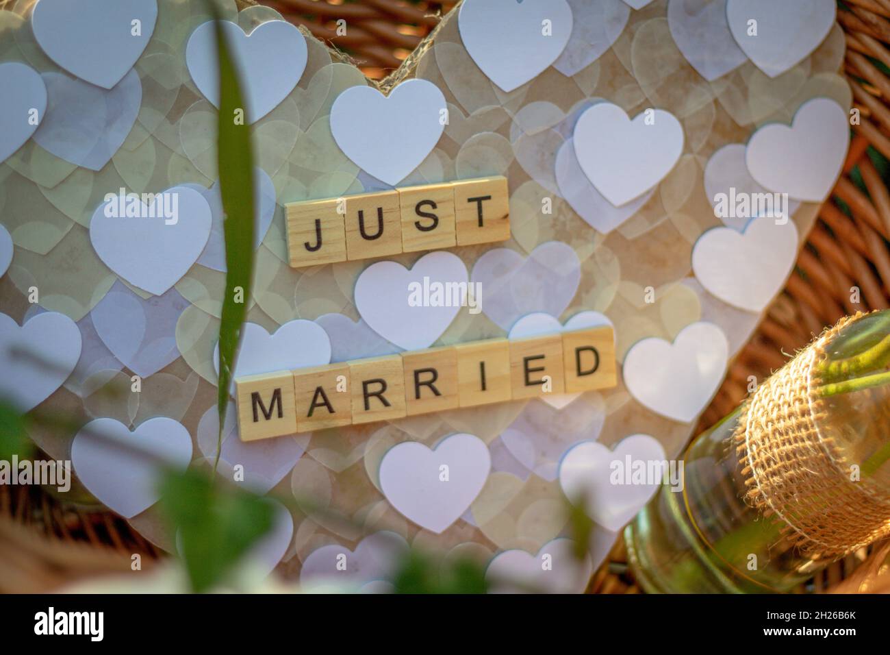 a heart with the words Just married made of single wooden letters in a basket as decoration at wedding celebration Stock Photo