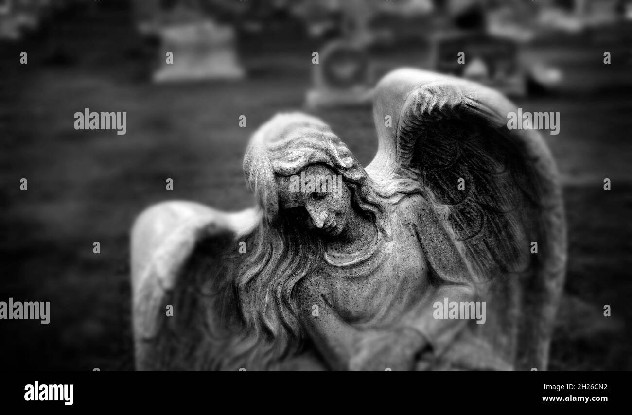Gravestone grave stone headstone in cemetery angel statue grief and remembrance wings and prayer Stock Photo