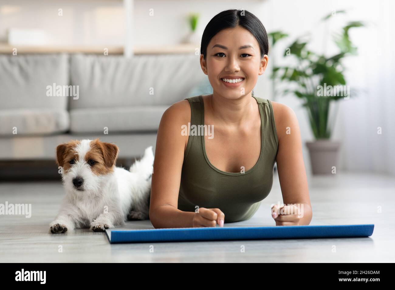 Loyal puppy exercising with its owner athletic asian woman Stock Photo