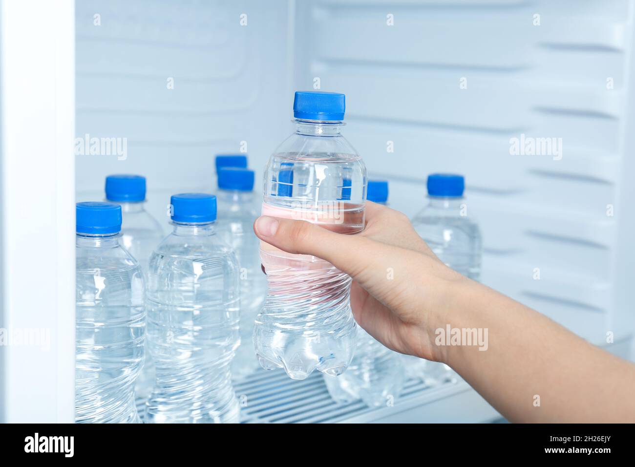 Woman taking bottle of water from refrigerator, closeup Stock Photo Alamy