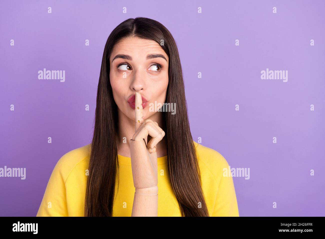 Photo of young silent brunette woman look empty space wooden finger lips isolated on purple color background Stock Photo