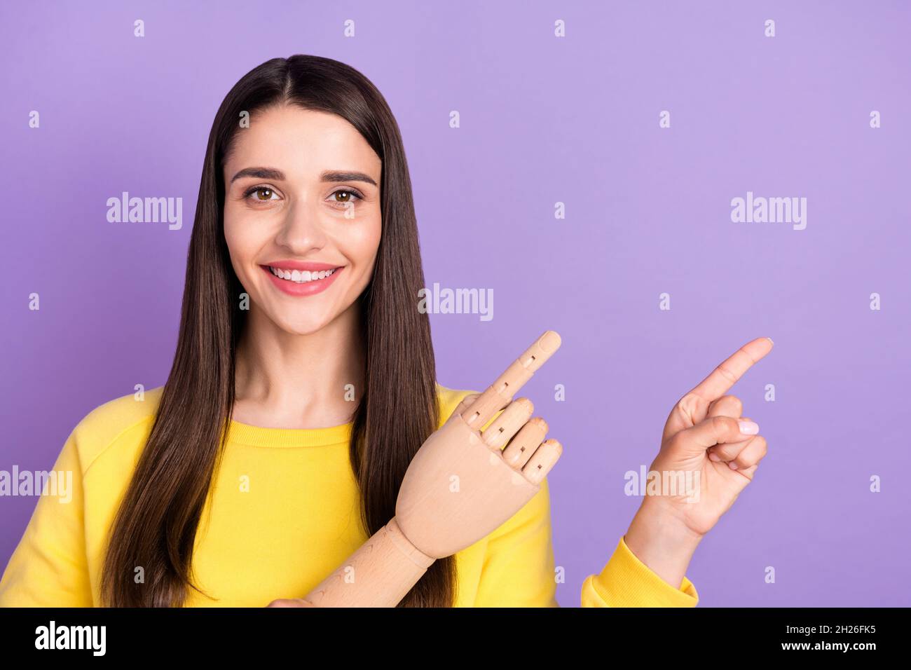 Photo of cheerful young happy woman point finger empty space sale wooden hand isolated on violet color background Stock Photo