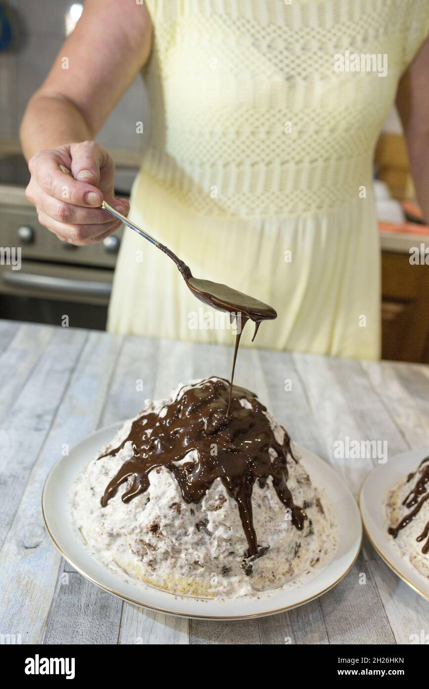 A step-by-step process for making a sour cream chocolate cake. The formed cake is poured with liquid chocolate icing. Stock Photo