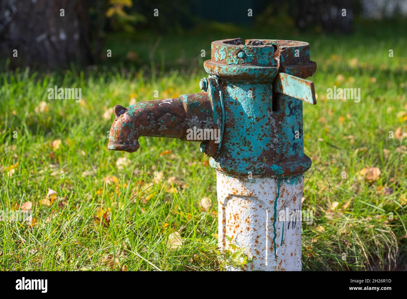 Old rusty water column in autumn, selective focus, blurred background Stock Photo