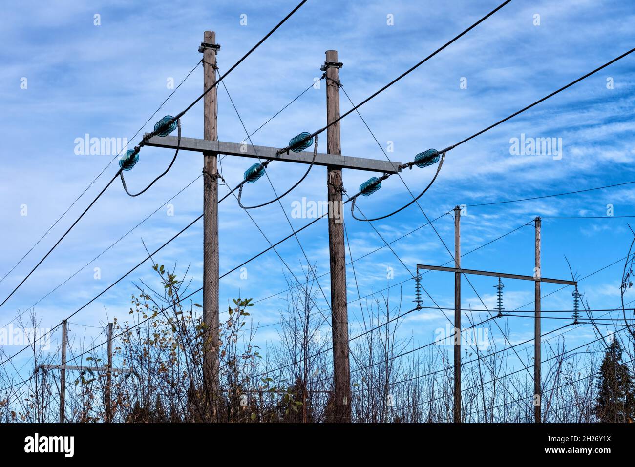 Power Source Line Power supply line with three wires mounted on old wooden pillar, blue ...