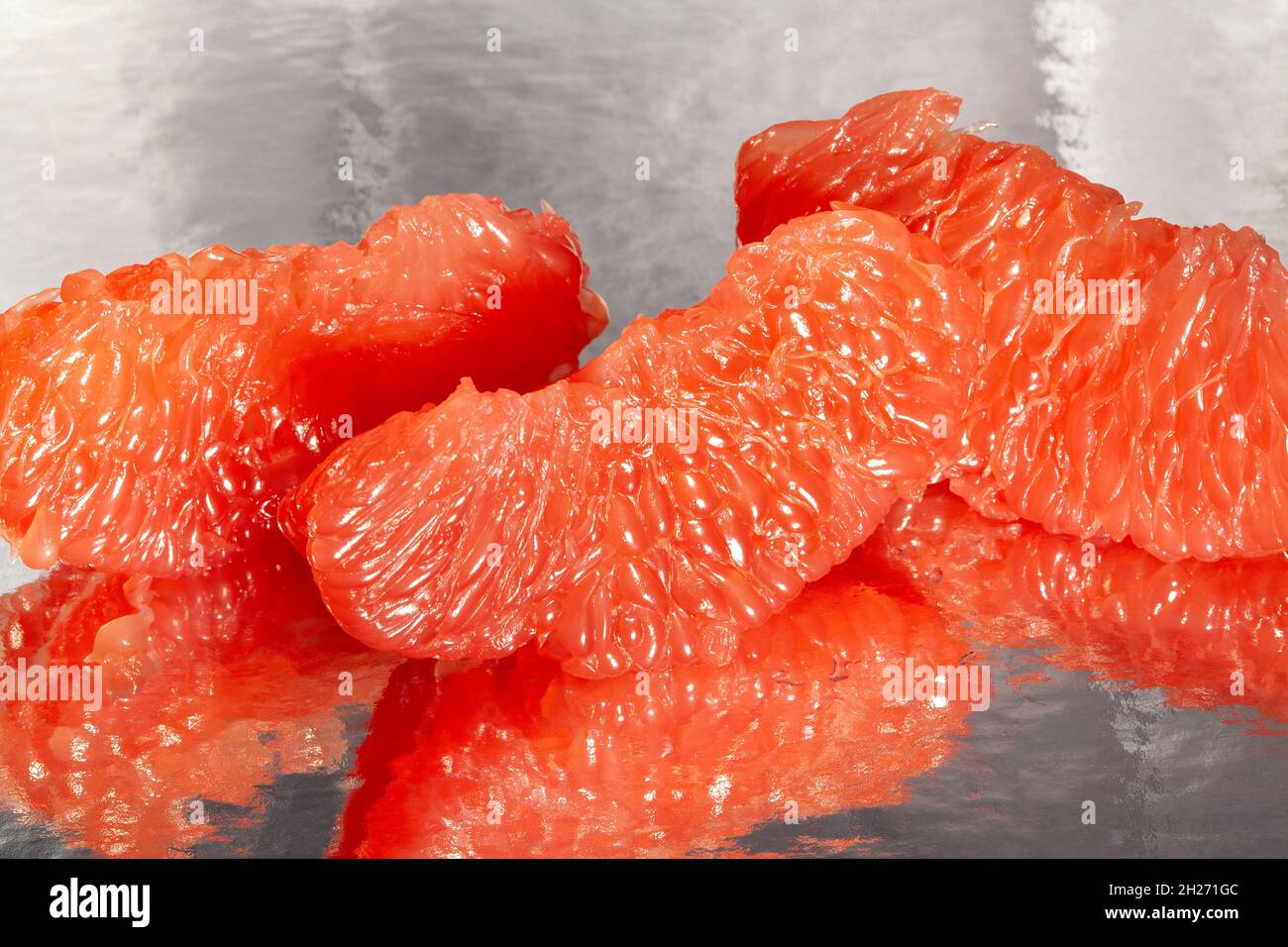 sliced mirrored grapefruit on black background Stock Photo