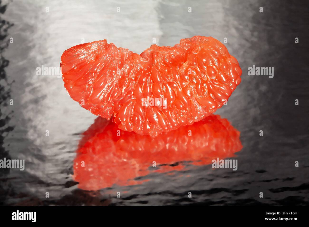sliced mirrored grapefruit on black background Stock Photo