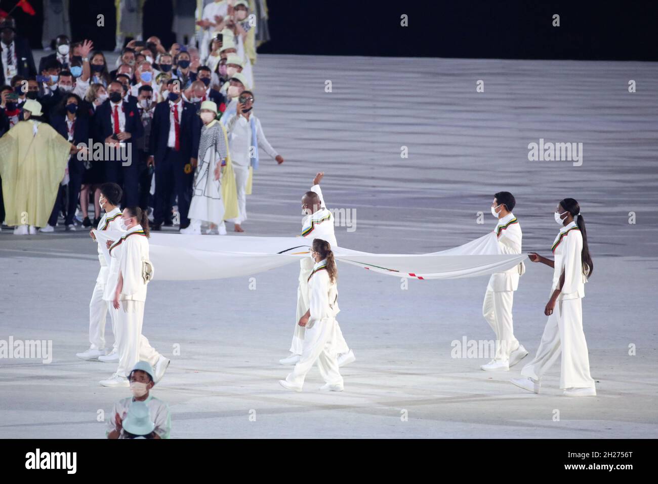 JULY 23rd, 2021 - TOKYO, JAPAN: the Olympic Flag enters the stadium carried by Kento Momota for Asia, Elena Galiabovitch for Oceania, Paula Pareto for Stock Photo