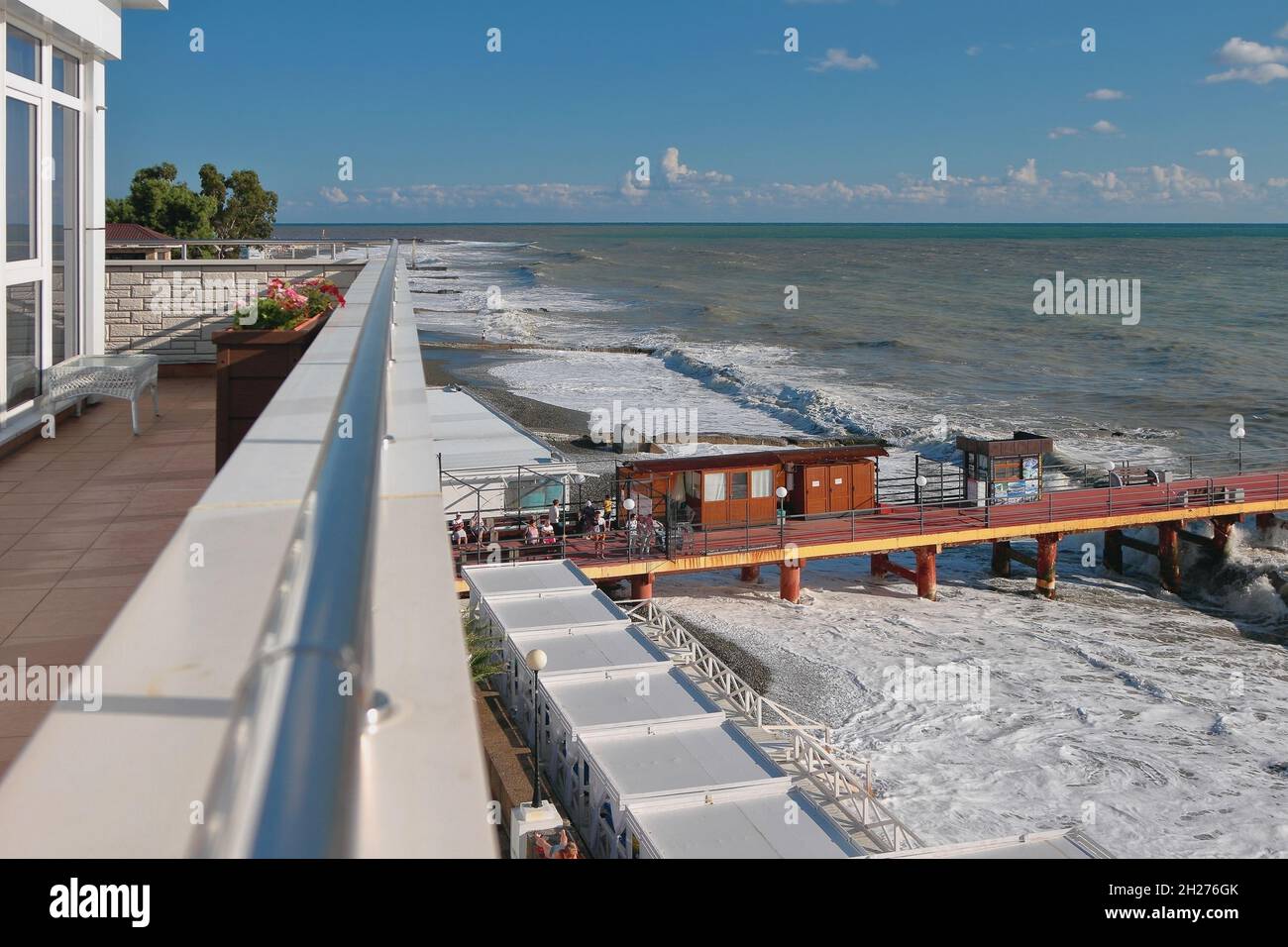 View from balcony to promenade, pier and stormy sea. Adler, Sochi, Russia Stock Photo