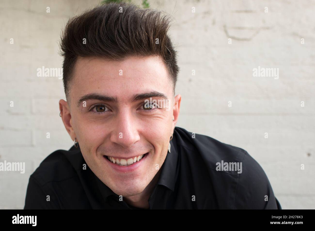 Close up of an attractive young man, smiling and looking at camera ...