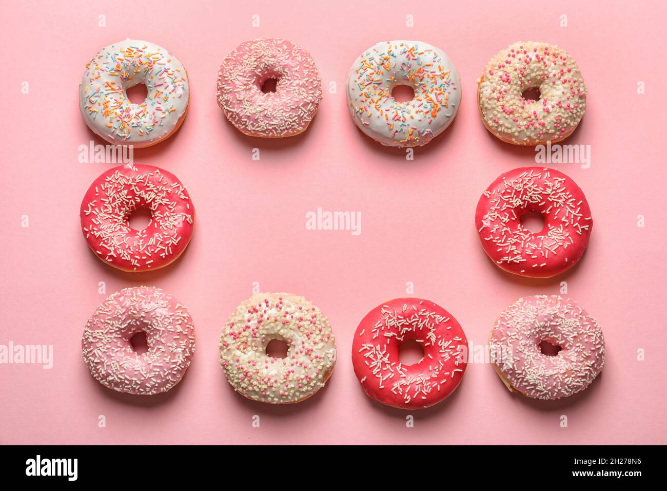 Frame made of delicious glazed doughnuts on color background, top view ...