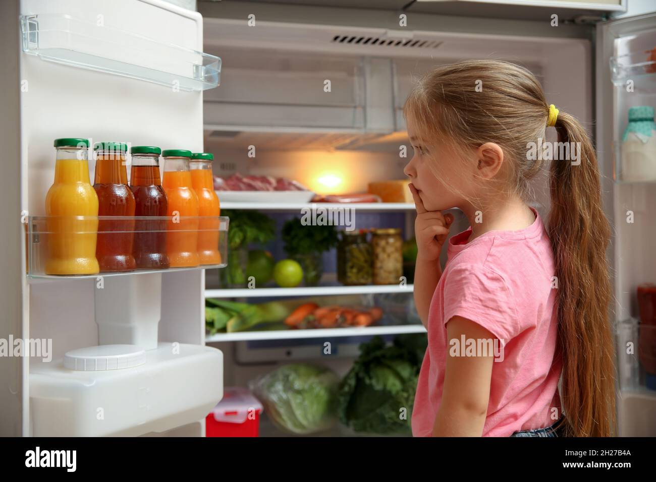 Cute little girl choosing food in refrigerator at home Stock Photo Alamy