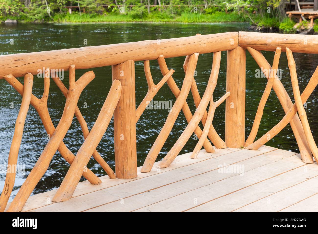 Natural wooden railings of an empty footbridge in a summer park ...