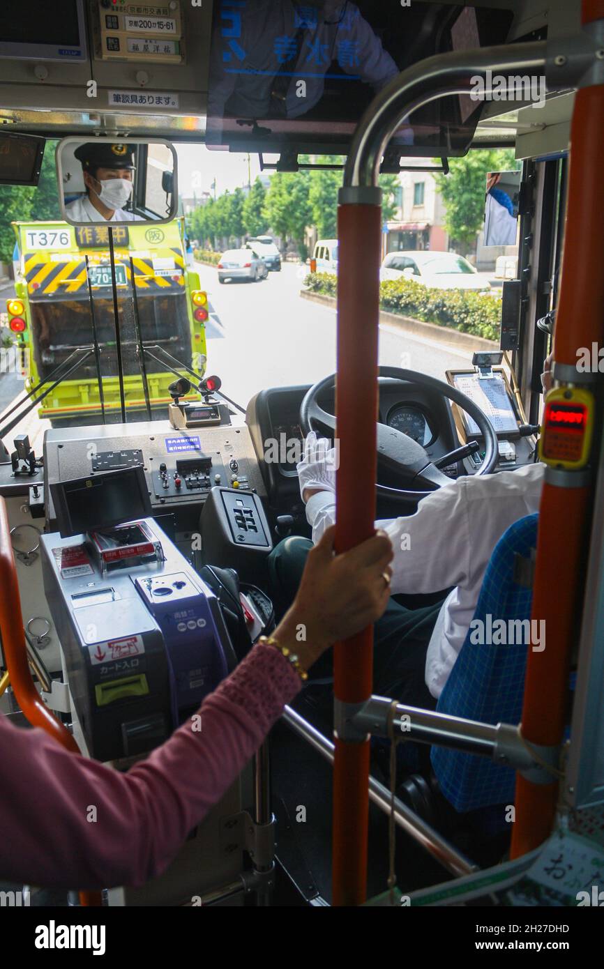 Kyoto city bus driver wearing white gloves in seat holding steering