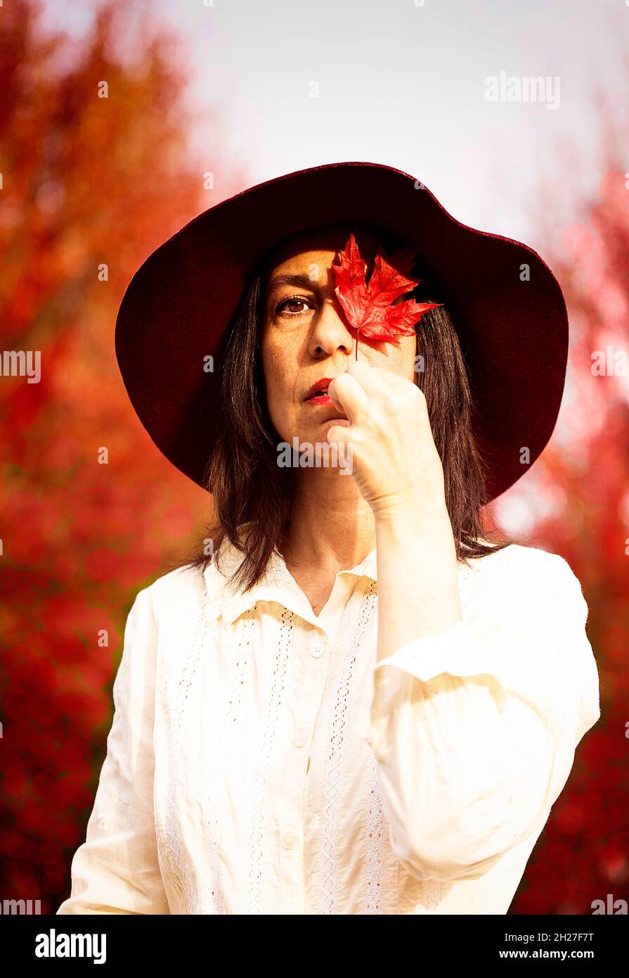 woman in red hat in an autumnal park II Stock Photo