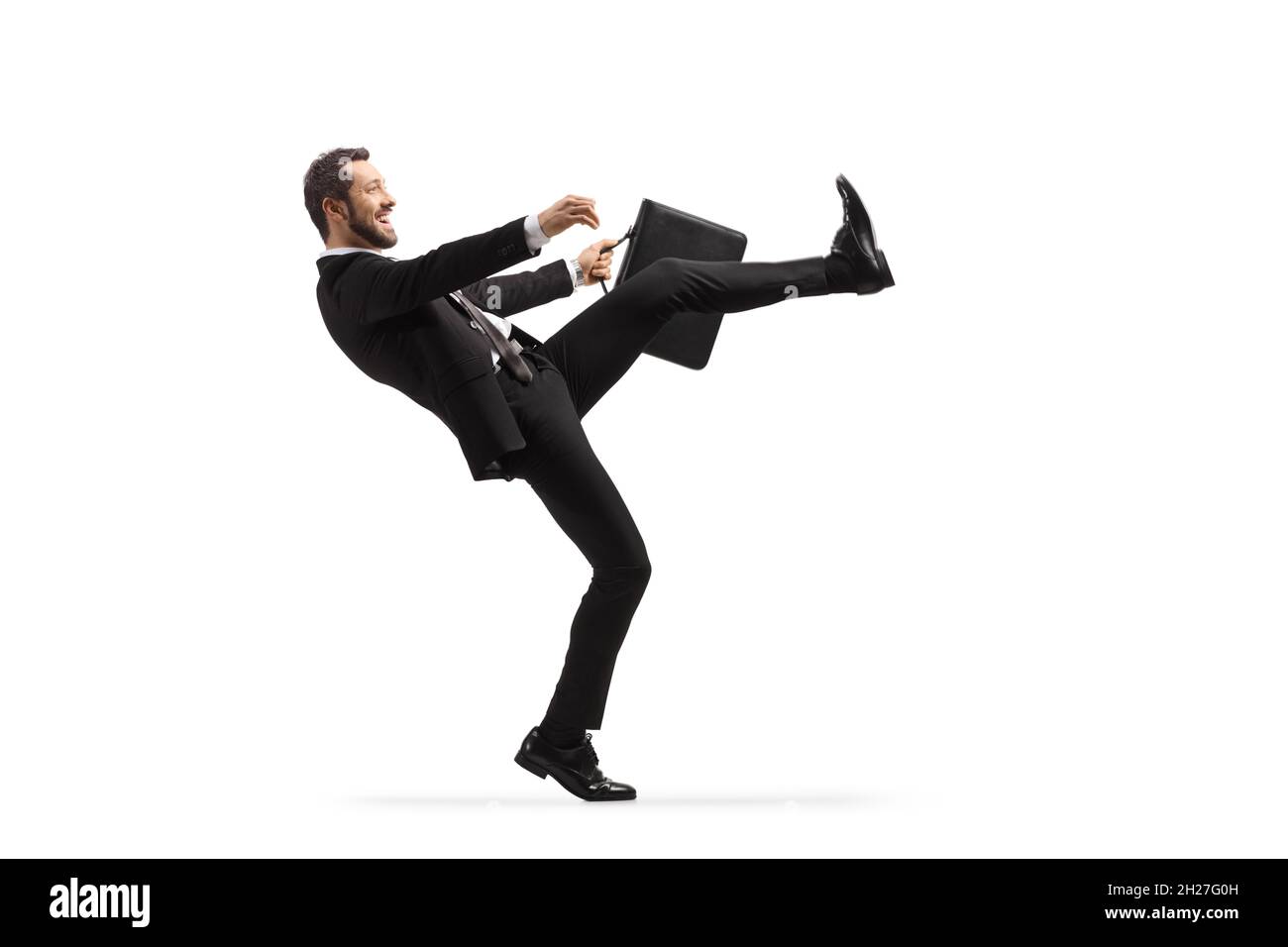 Full length profile shot of a businessman doing a silly walk isolated on white background Stock Photo