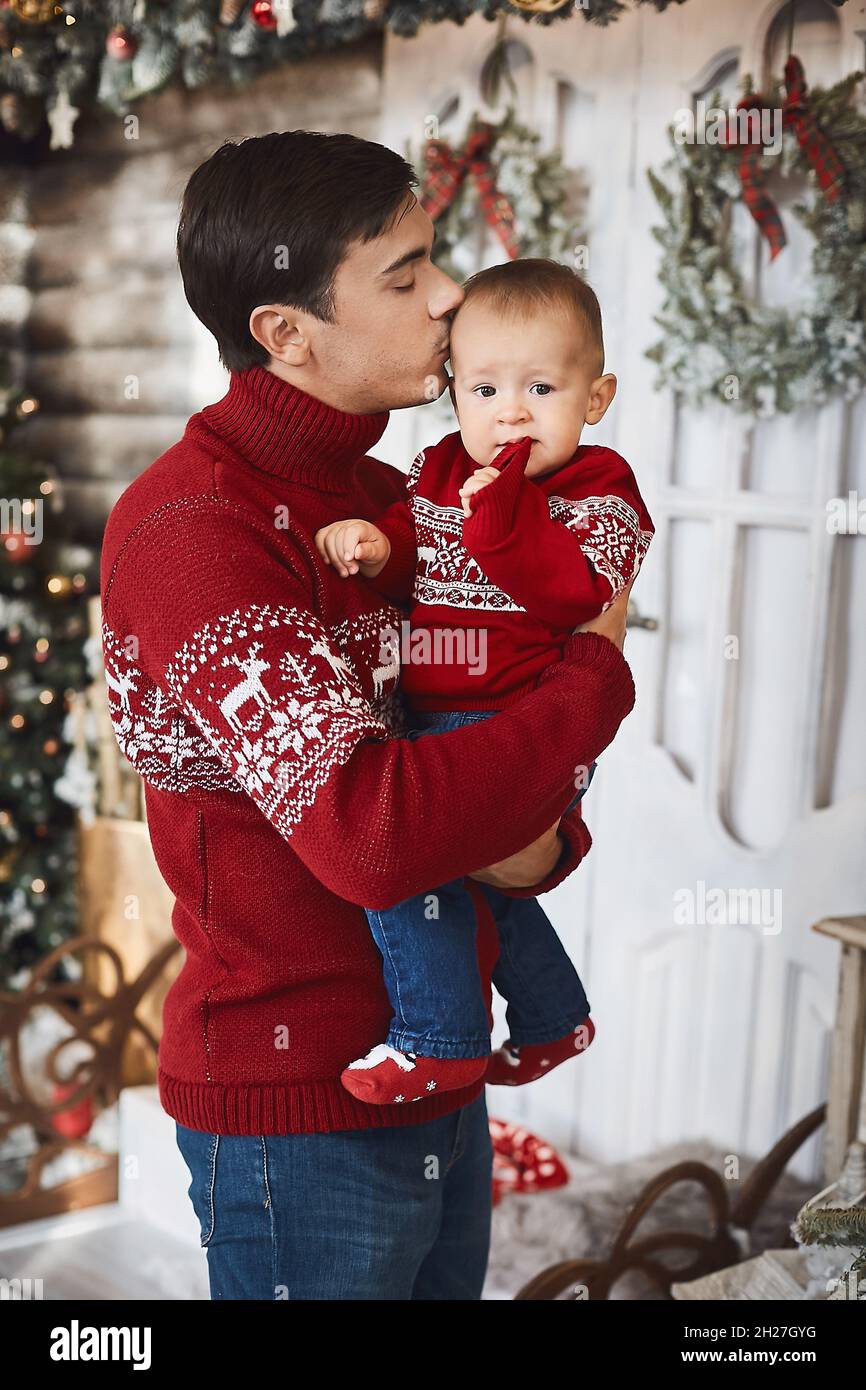 Handsome man and his little son in ugly sweaters in the decorated for Christmas interior Stock Photo Alamy