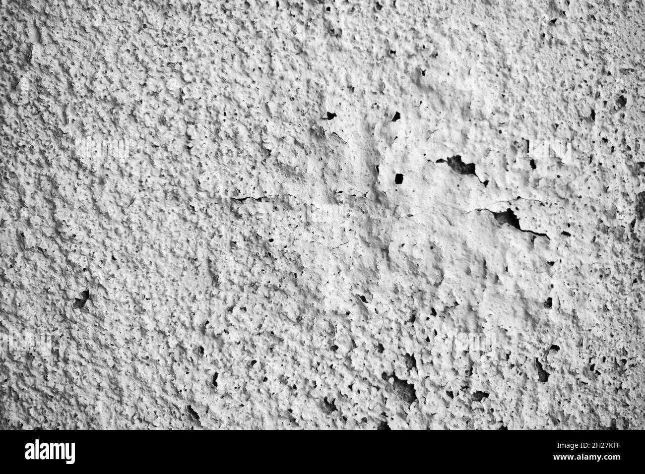 White damp wall showing paint cracking open and breaking or peeling off