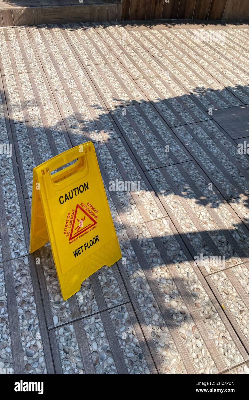 sign showing warning of caution wet floor, cleaning service, wet floor sign near swimming pool or on vacation Stock Photo