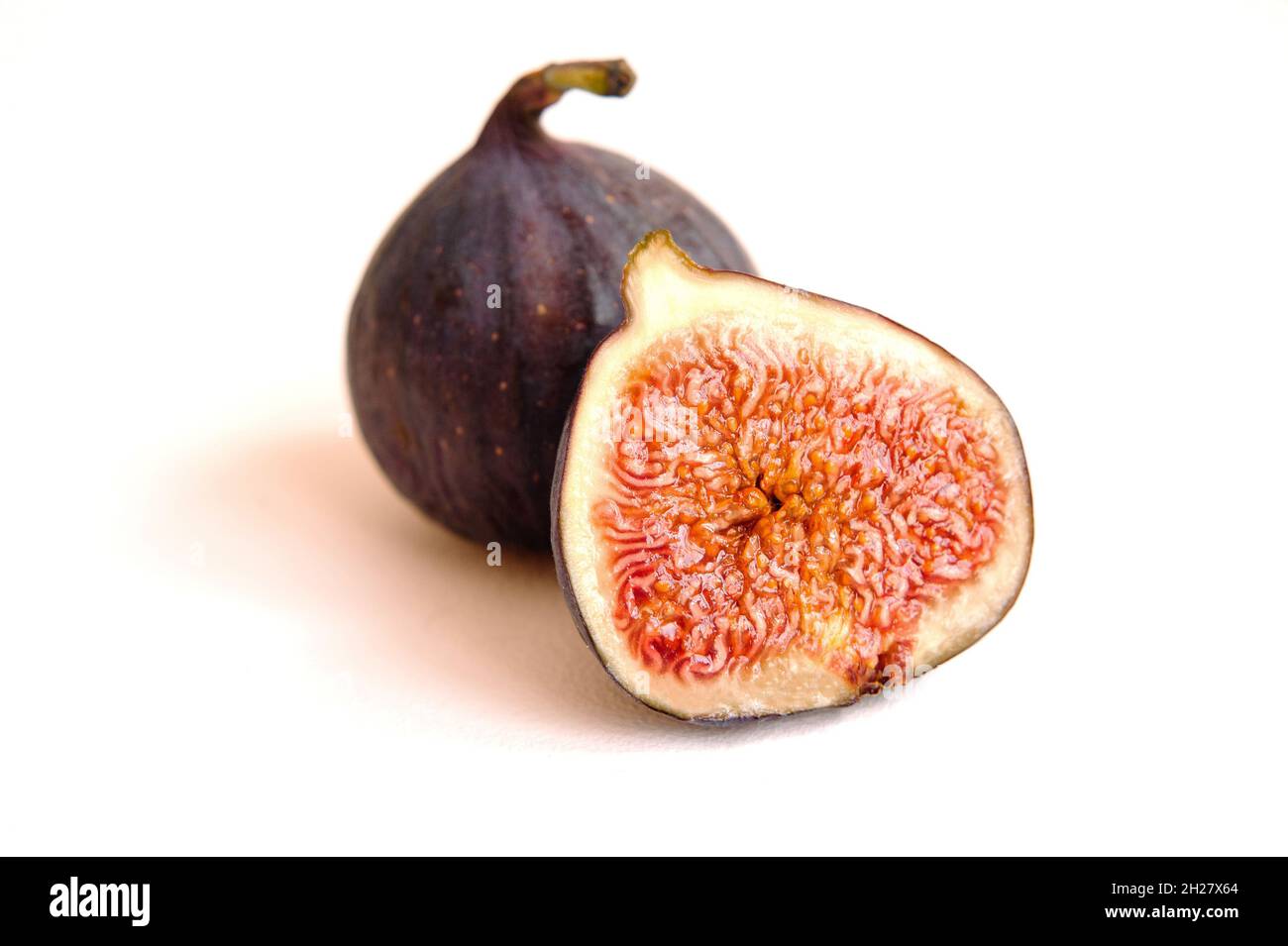 Fresh whole and bisected figs isolated on white background. Stock Photo
