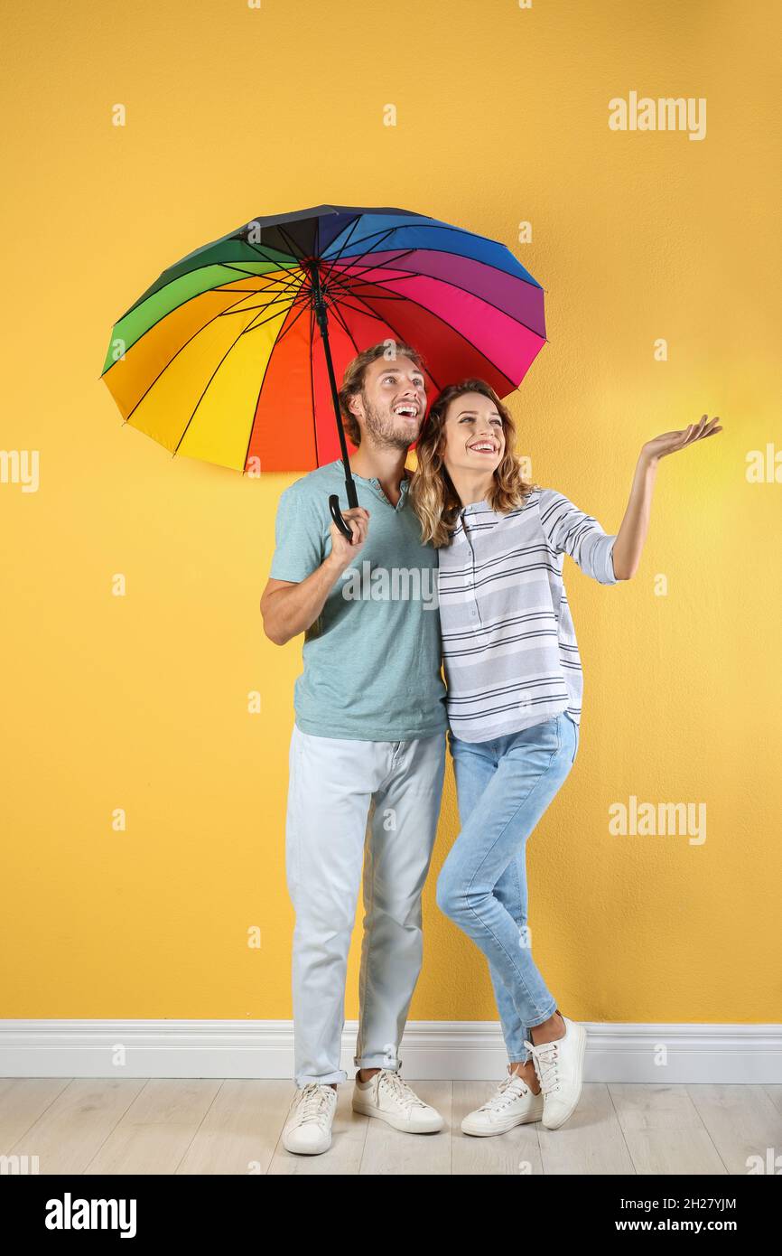 Couple with rainbow umbrella near color wall Stock Photo Alamy