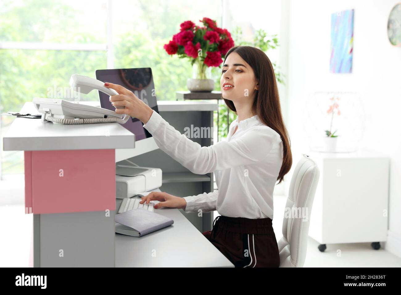 Beauty salon receptionist using computer at desk Stock Photo Alamy