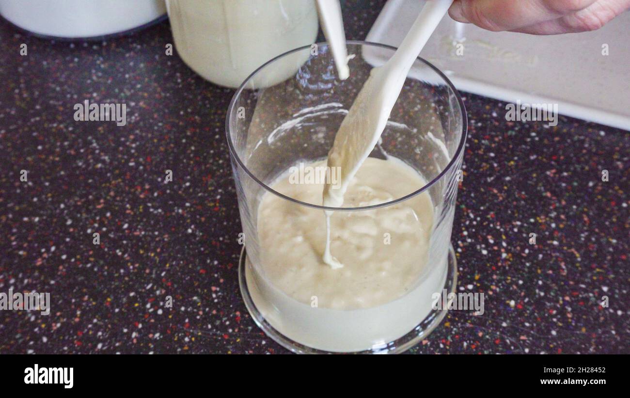 Feeding sourdough starter with water and flour Stock Photo Alamy