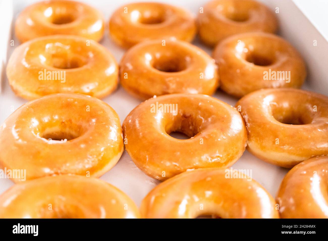 Plain glazed storebought doughnuts in a white paper box Stock Photo