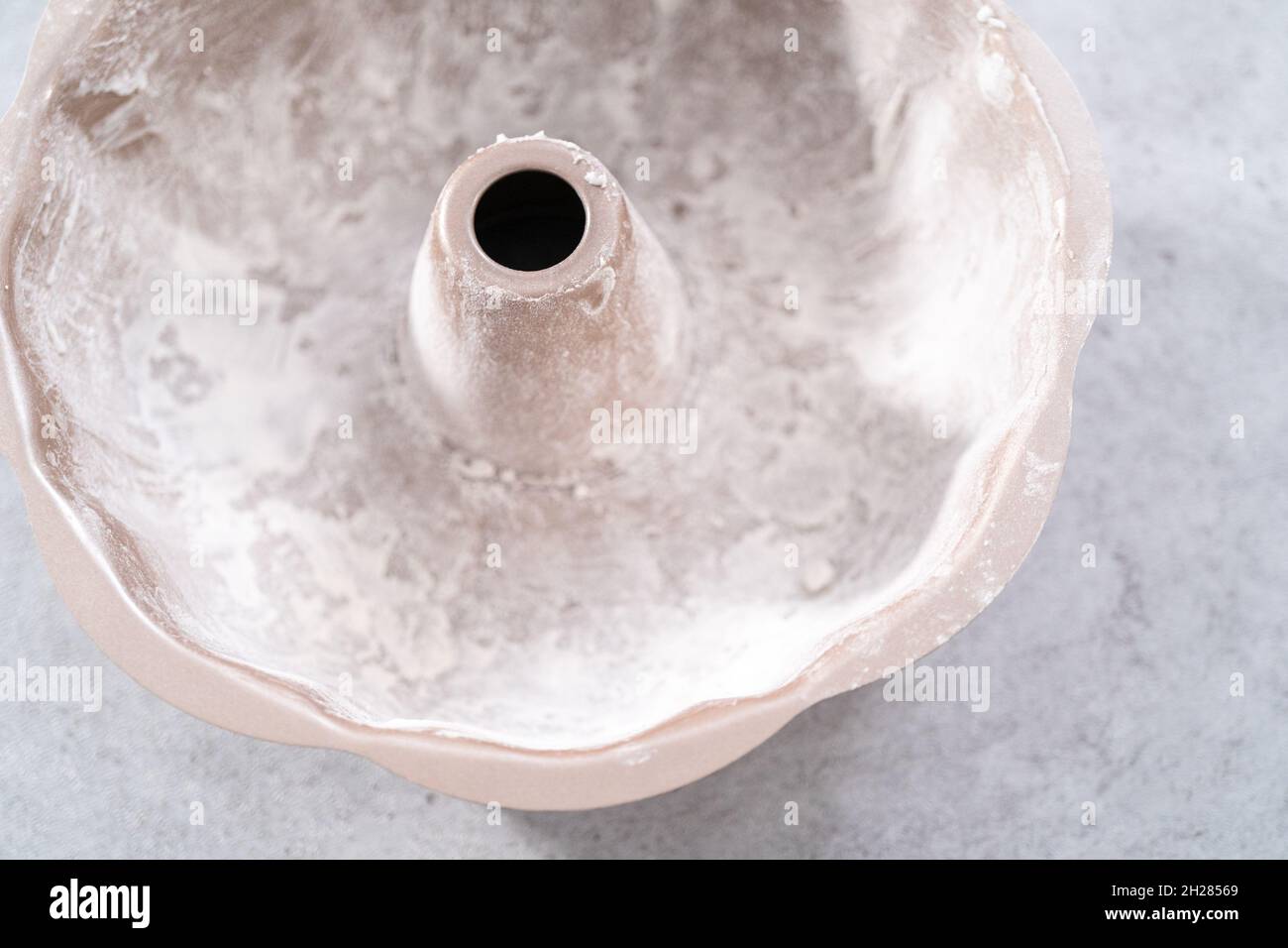Greasing bundt cake pan to bake lemon cranberry bundt cake Stock Photo