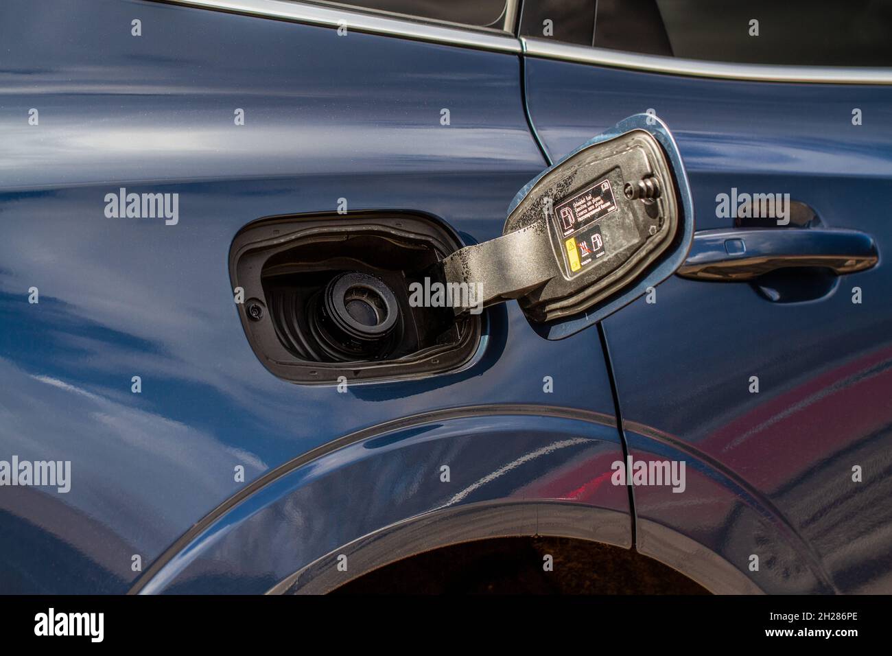 Exterior of car with fuel filler door open. Opened fuel tank cap