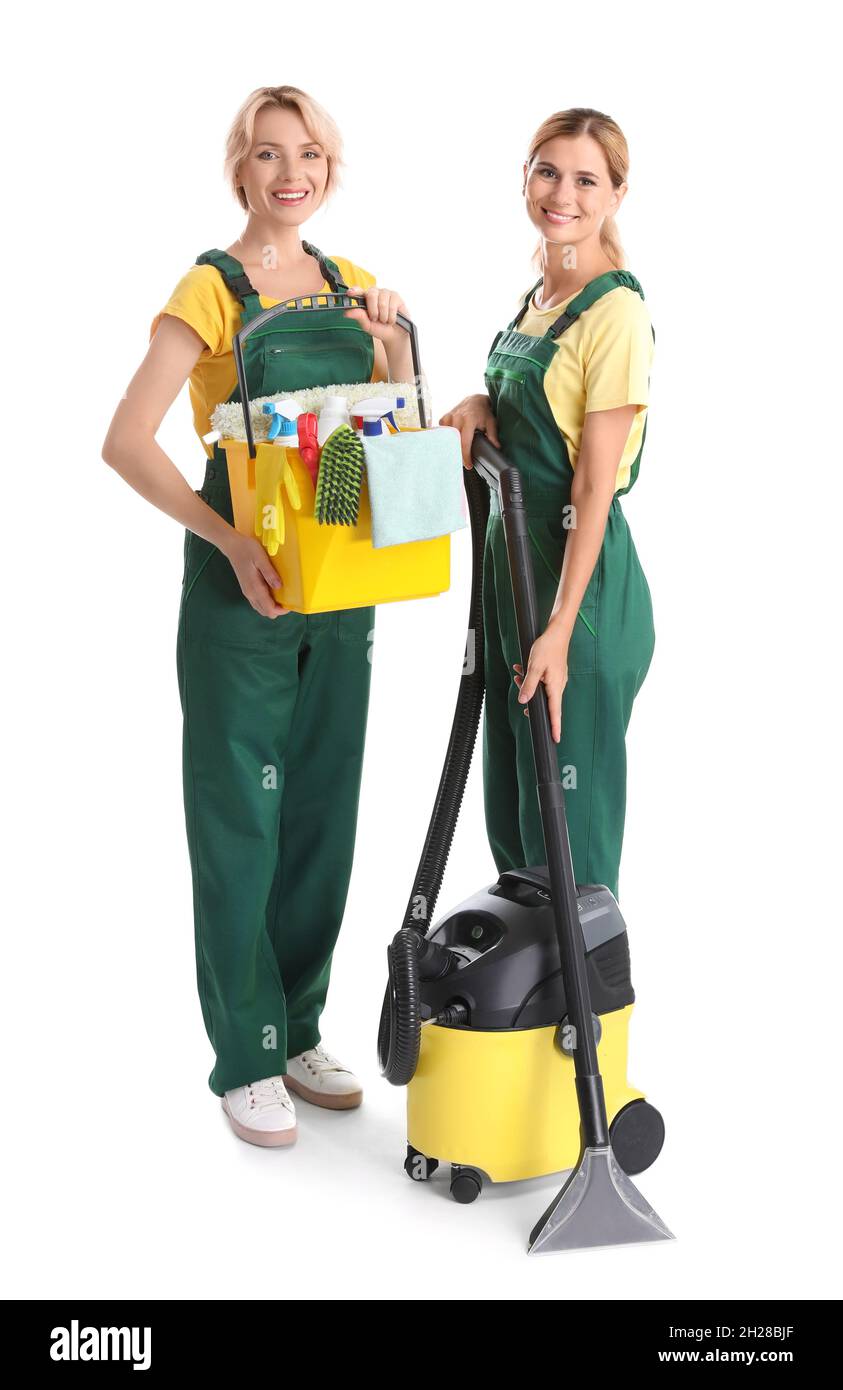 Female janitors with cleaning equipment on white background Stock Photo