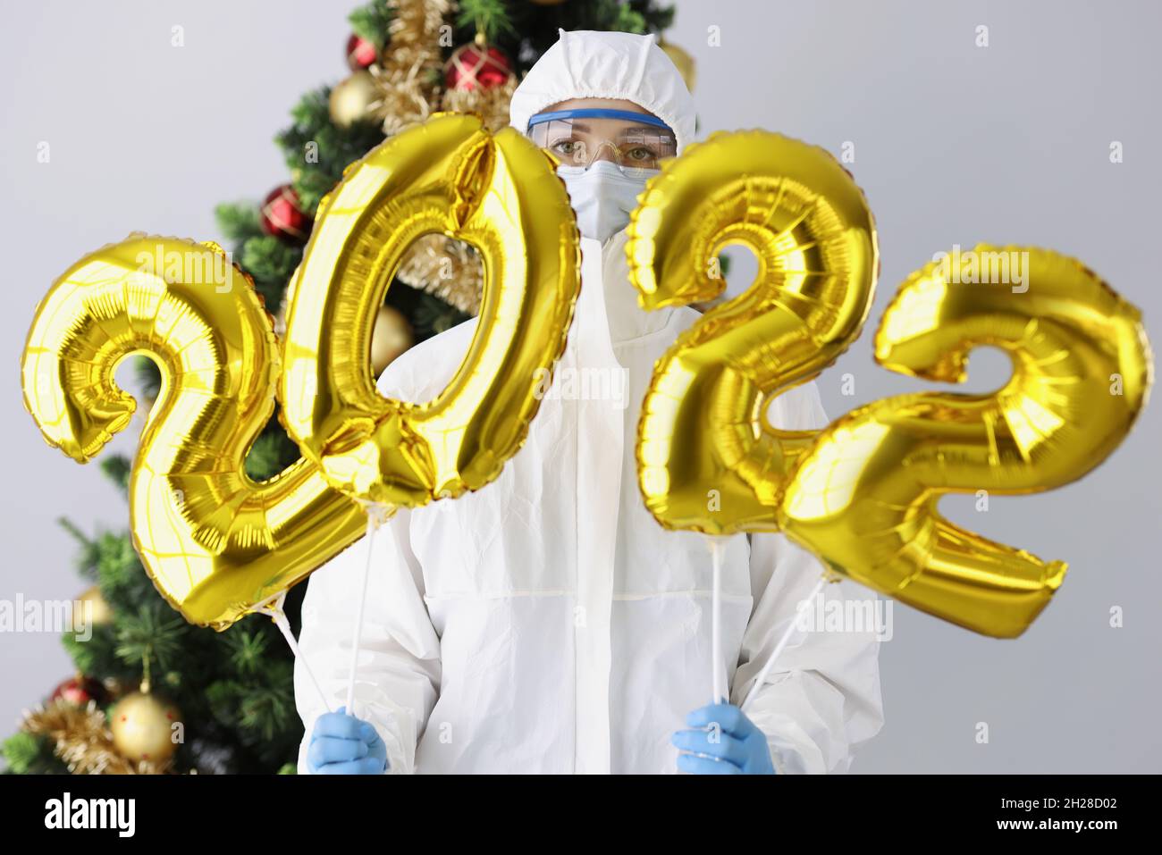 Docor Who Christmas 2022 Doctor In Protective Suit, Mask And Glasses Holds Numbers 2022 Against  Background Of New Year Tree Stock Photo - Alamy