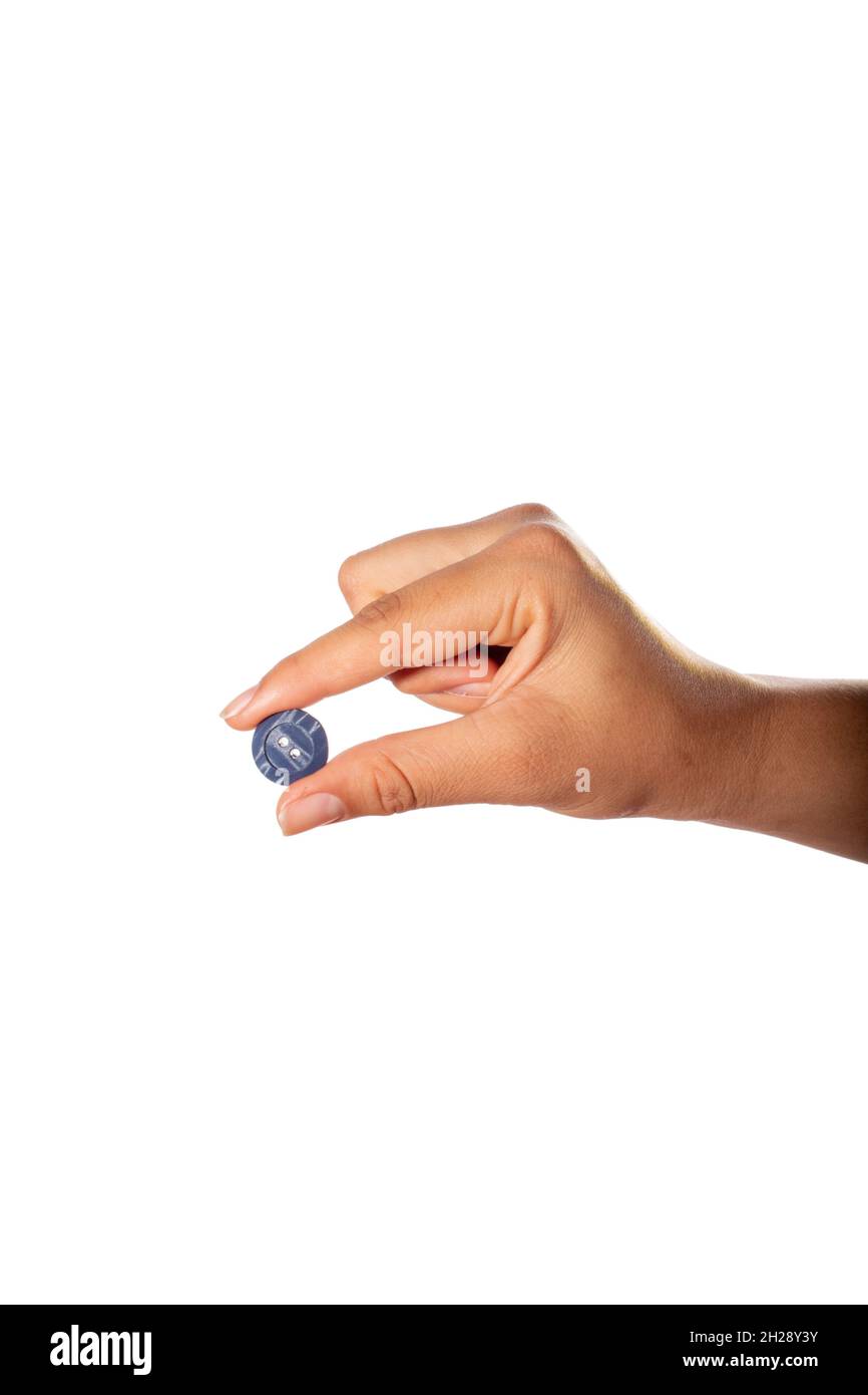 Hand holding blue clothes button. Isolated on white background. Stock Photo