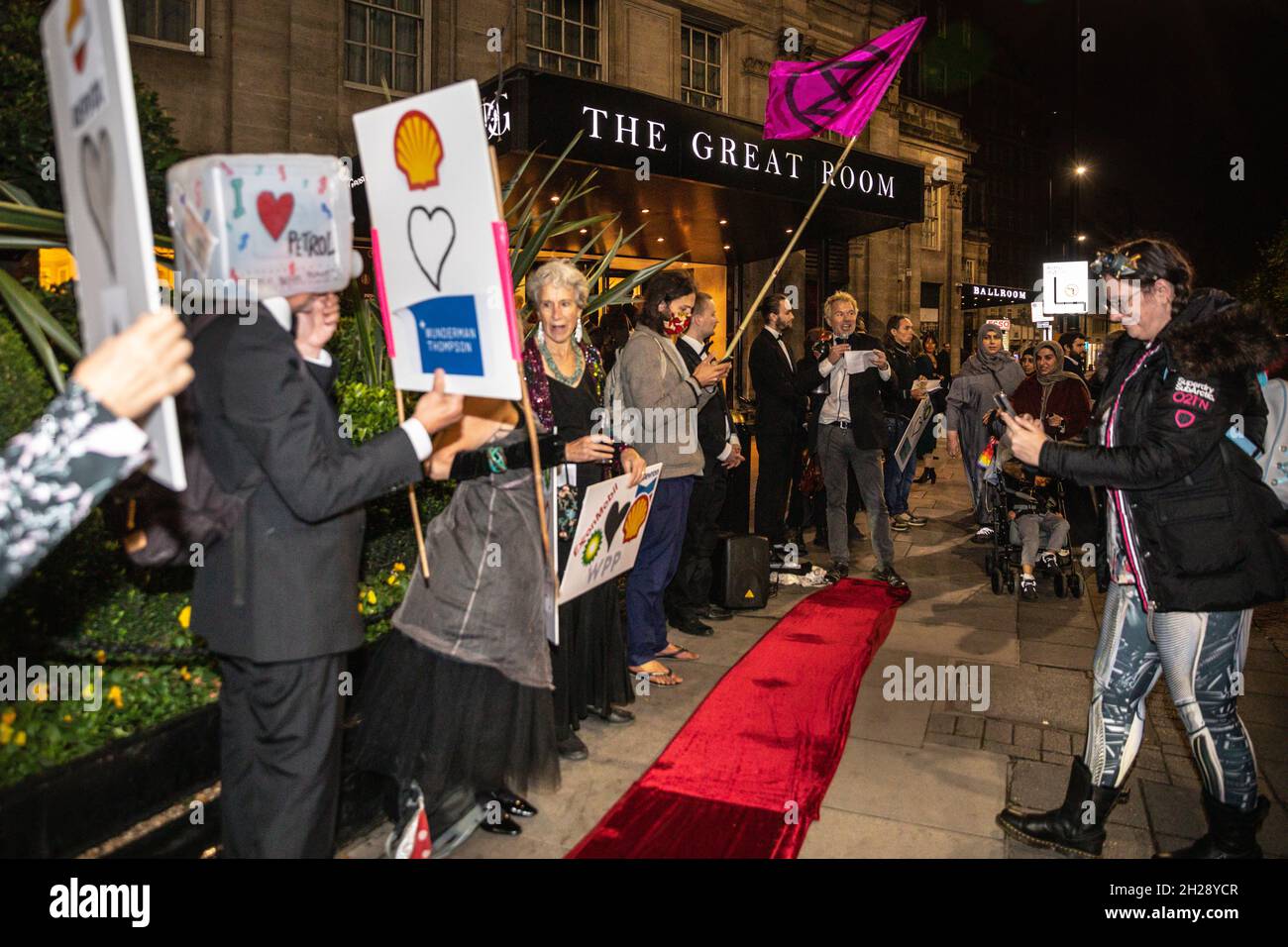 Park Lane, London, UK. 20th Oct, 2021. Activists from XR Exctinction Rebellion Greenwash protest outside the PR Week Awards at Grosvenor House this eve. The protesters, in eveningwear, have brought their own red carpet to award the 'Greenwashers in Chief' and rally against PR firms who work for fossil fuel companies. Credit: Imageplotter/Alamy Live News Stock Photo
