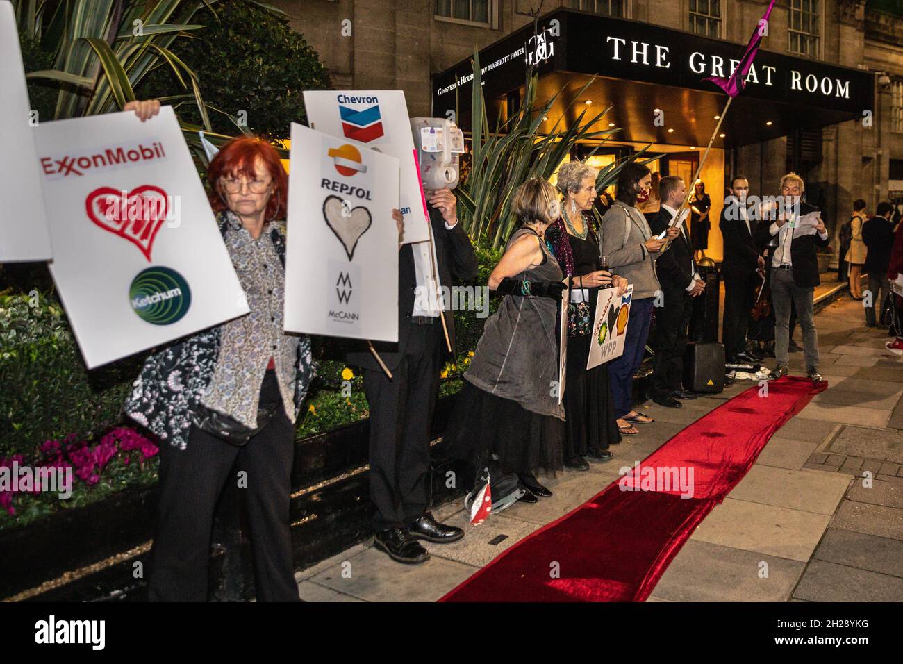 Park Lane, London, UK. 20th Oct, 2021. Activists from XR Exctinction Rebellion Greenwash protest outside the PR Week Awards at Grosvenor House this eve. The protesters, in eveningwear, have brought their own red carpet to award the 'Greenwashers in Chief' and rally against PR firms who work for fossil fuel companies. Credit: Imageplotter/Alamy Live News Stock Photo