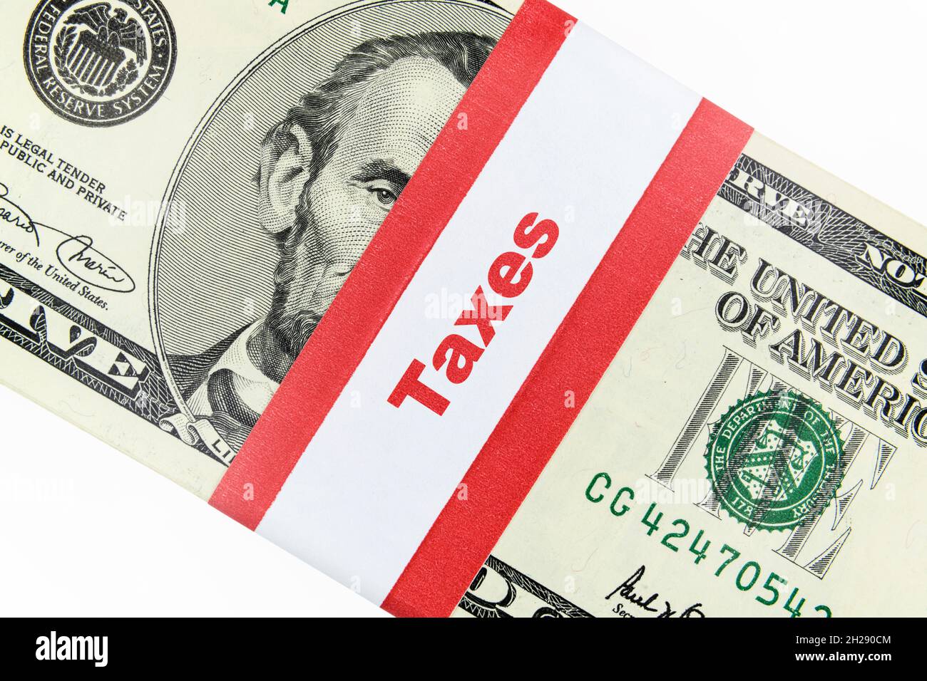 Close up of taxes label on five dollar money bundle currency strap. Stock Photo