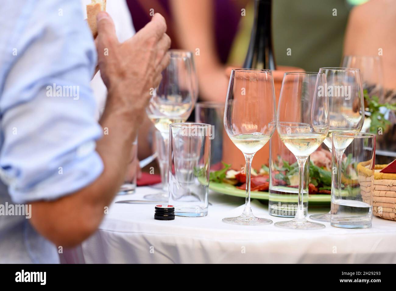 Einige Weingläser auf einem Stehtisch im Sommer - Some wine glasses on a bar table in Summer Stock Photo