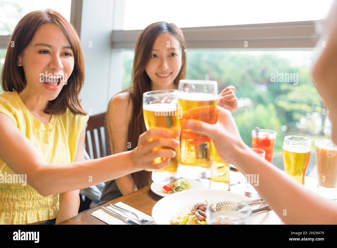 Happy Young group enjoying food and drink in restaurant Stock Photo