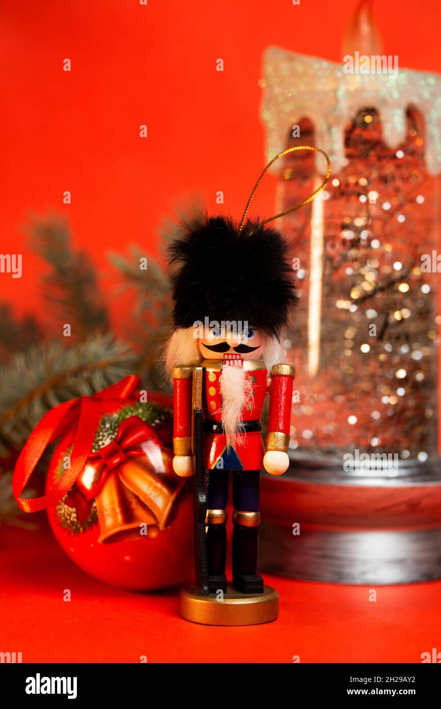 christmas nutcracker figurine with decorations on a red background. Stock Photo