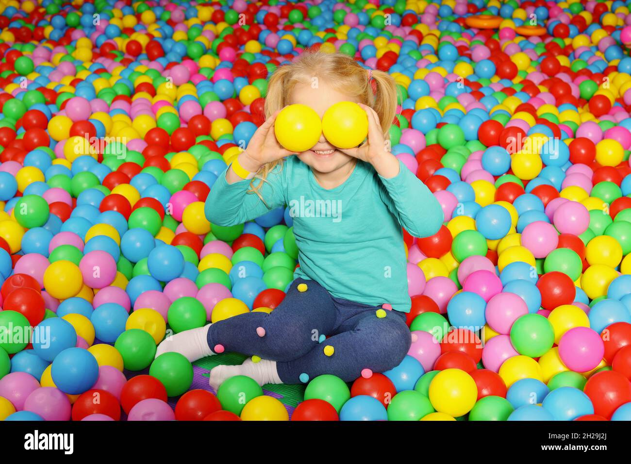 Cute child playing in ball pit indoors Stock Photo Alamy