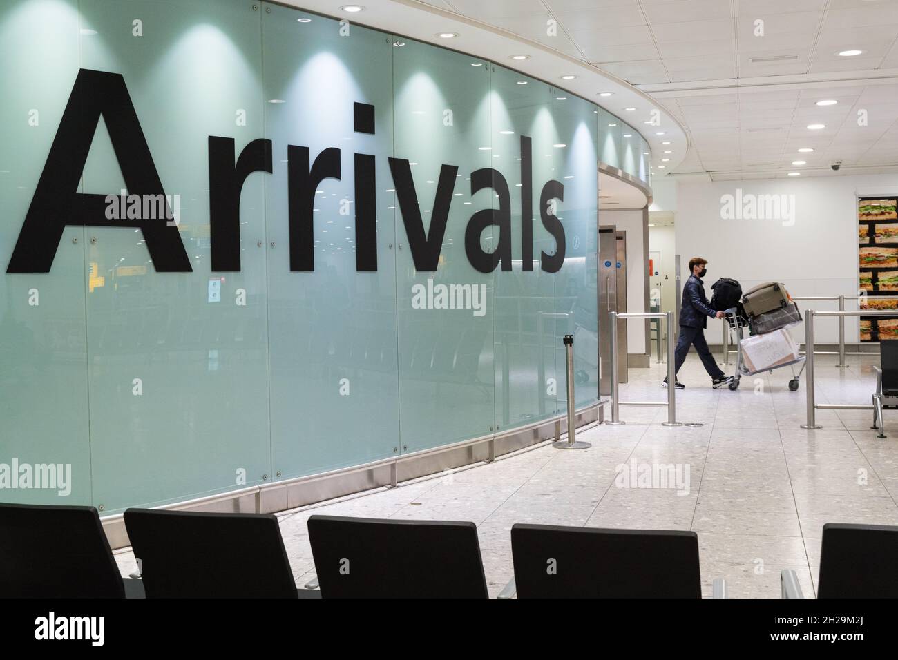 Air passengers arrive at arrival hall at Heathrow International airport London England UK Stock Photo