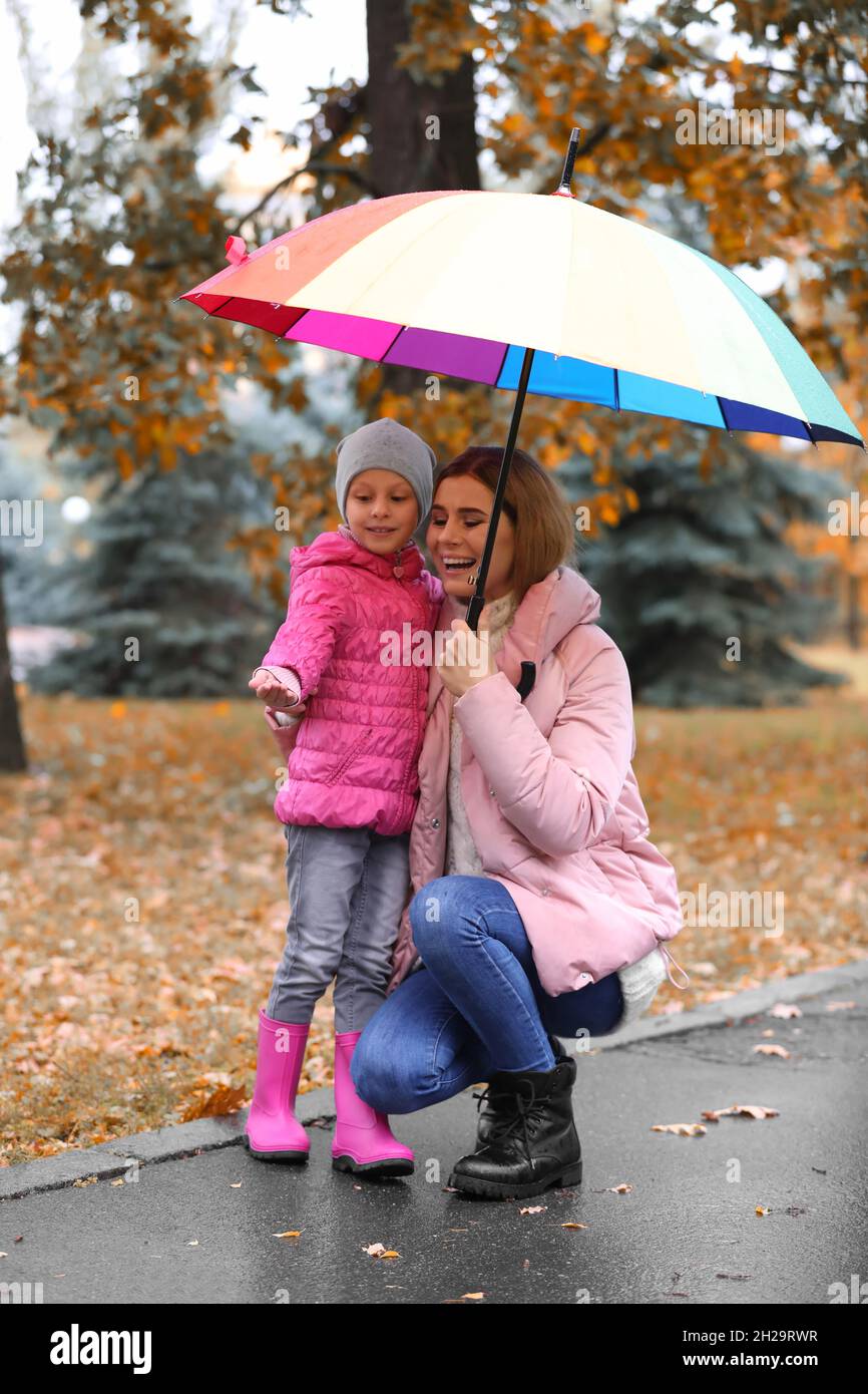 Mother and daughter with umbrella in autumn park on rainy day Stock ...