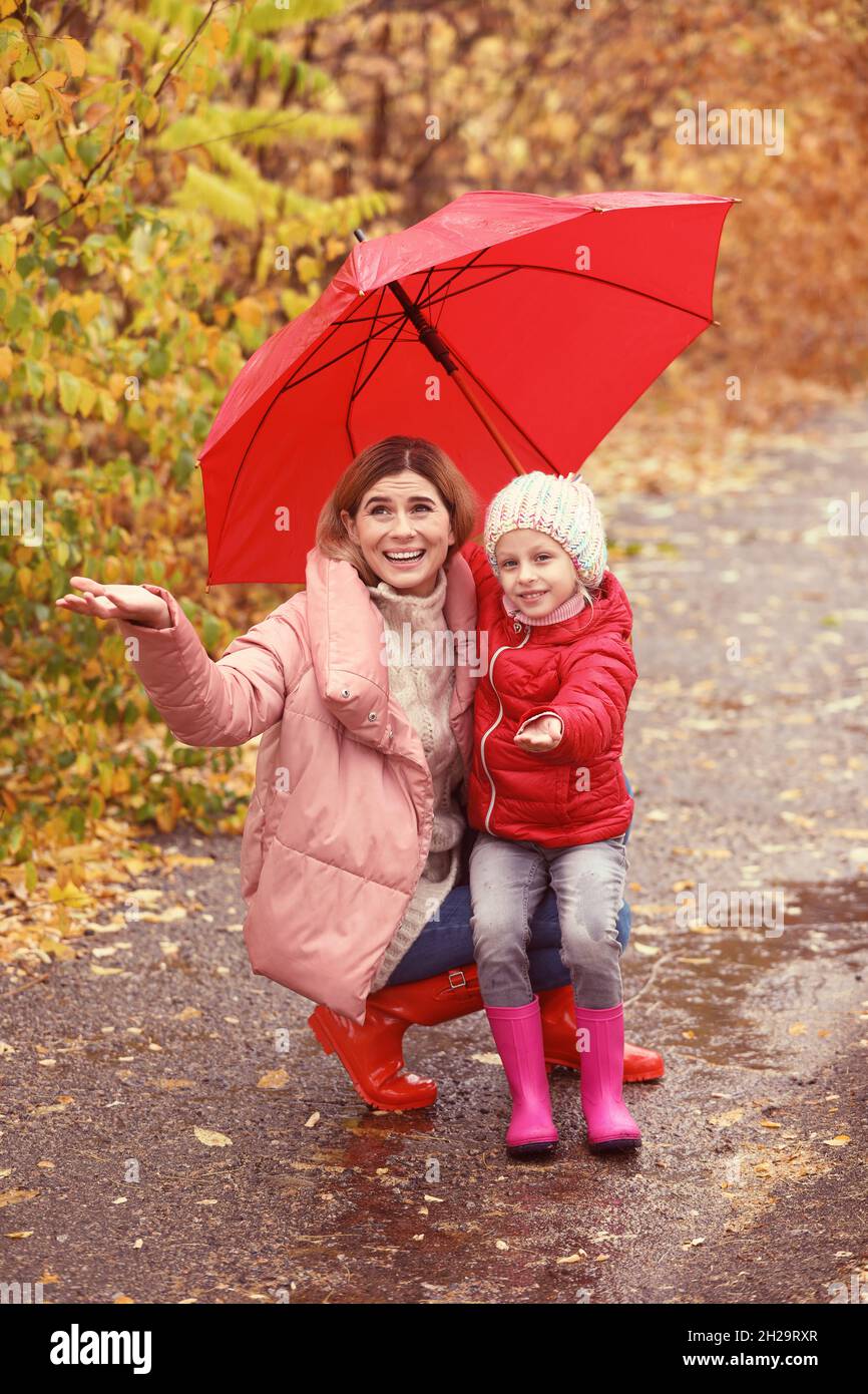 Mother and daughter with umbrella in autumn park on rainy day Stock ...